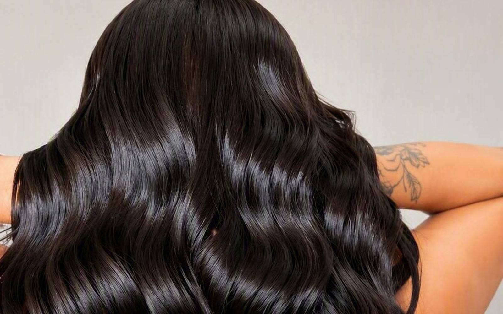 Long, glossy dark waves, seen from behind.